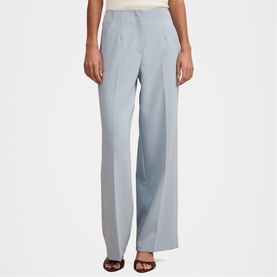 Model wearing Forever New sky blue wide-leg tailored trousers with front pleats, styled with black heeled mules.