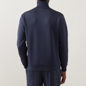 Model wearing Les Deux Casual Jacket in India Ink Blue, rear view, half-zip funnel neck, styled with matching navy trousers