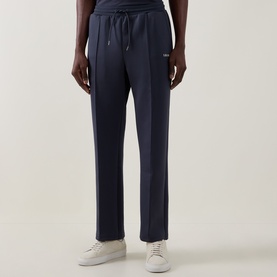 Model wearing Les Deux India Ink Blue sweatpants with drawstring waist, styled with white trainers