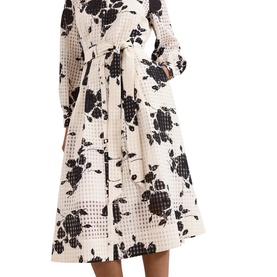 Model wearing Phase Eight white midi dress with black floral and grid print, long sleeves, V-neckline, and belted waist with full skirt.