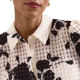 Model wearing Phase Eight white floral print shirt with grid texture, black rose pattern, collared neckline with button fastening