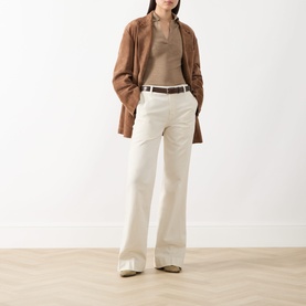 Model wearing Seven Jeans Modern Dojo High-Rise Wide Leg Jeans in ecru, styled with a brown coat, knit top, and thin belt.
