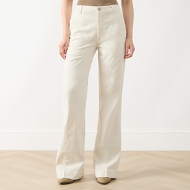 Model wearing Seven Jeans Modern Dojo High-Rise Wide Leg Jeans in ecru, wide-leg twill with five-pocket styling, paired with beige heeled mules.