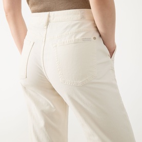 Model wearing Seven Jeans Modern Dojo High-Rise Wide Leg Jeans in ecru, showing rear five-pocket detail and wide-leg silhouette, styled with a beige