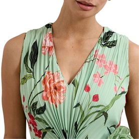 Model wearing mint green pleated sleeveless top with pink and green floral print, V-neckline, close-up crop view
