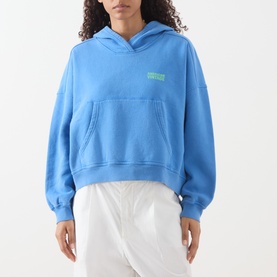 Model wearing American Vintage Plizzy Logo Hoodie in Nautique Vintage, oversized fit with front pouch pocket and green logo print, styled with white