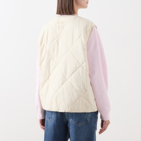 Model wearing American Vintage cream quilted gilet, styled with a pink long-sleeve top and blue jeans, back view.