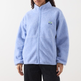 Model wearing American Vintage Hoktown Logo Fleece Jacket in Givre Chine, zip-up sherpa fleece with stand collar and logo patch detail.