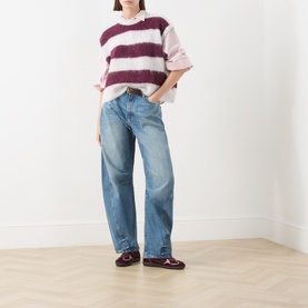 Model wearing American Vintage knitwear in rayures cranberry stripe, styled with light blue wide-leg jeans and burgundy loafers.