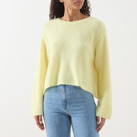 Model wearing American Vintage Vitow Knitted Sweater in Citronnier Chine, boat neckline, long sleeves, styled with light blue jeans