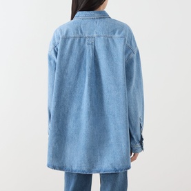 Model wearing American Vintage shirt in Authentique Stone denim, rear view, relaxed fit with button cuffs, styled with matching blue denim jeans