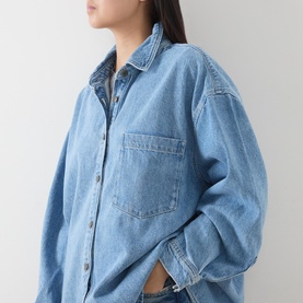 Model wearing American Vintage denim shirt in Authentique Stone, oversized fit with chest pocket and button-front, long sleeves