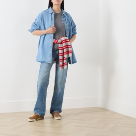 Model wearing American Vintage shirt in authentique stone, styled with light wash jeans, grey tee and red striped jumper tied at waist.