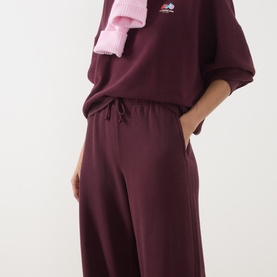 Model wearing American Vintage Atubay Drawstring Wide Leg Sweatpants in Lie de Vin, wide leg fit with elasticated waist, styled with matching