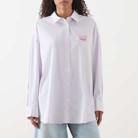 Model wearing American Vintage shirt in Rayures Douceur, relaxed fit with button placket, chest graphic, styled with light blue jeans