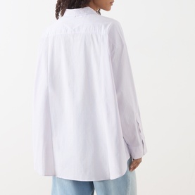 Model wearing American Vintage shirt in Rayures Douceur, rear view showing relaxed oversized fit, long sleeves, and button collar, styled with blue
