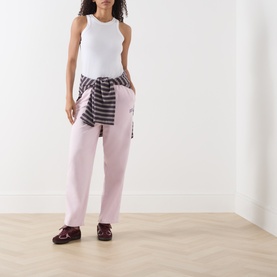 Model wearing American Vintage Sweat Bottom in Petale Vintage, styled with white sleeveless top and striped shirt tied at waist, burgundy shoes