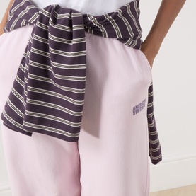 Model wearing American Vintage Sweat Bottom in Petale Vintage pink, styled with a navy striped top tied at the waist
