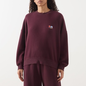 Model wearing American Vintage Atubay Logo Sweatshirt in lie de vin, crew neck, small chest logo, styled with matching sweatpants.