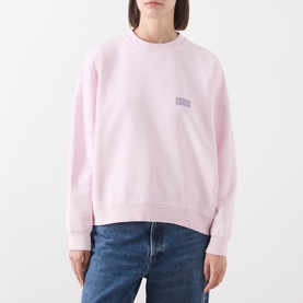 Model wearing American Vintage Sweat Top in Petale Vintage pink with small chest logo, styled with blue denim jeans.