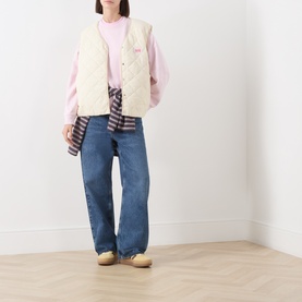 Model wearing American Vintage Petale Vintage sweat top styled with cream quilted gilet, plaid shirt and blue wide-leg jeans