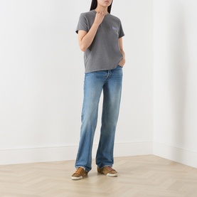Model wearing American Vintage granite chin&eacute; cotton T-shirt with wide-leg blue jeans and tan trainers