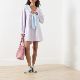 Model wearing American Vintage Soabird Striped Tunic in Rayures Douceur with light blue knitwear, carrying pink tote, wearing green trainers