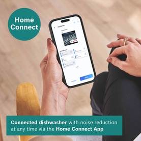 Person holding smartphone displaying Home Connect App interface for controlling a connected dishwasher remotely