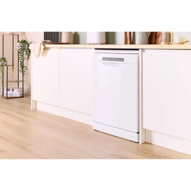 White freestanding dishwasher installed under kitchen counter with light wood flooring and white cabinetry in a bright modern kitchen