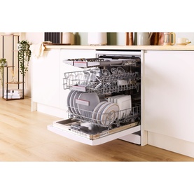 Freestanding white dishwasher with open door, three loaded rack tiers, integrated into a bright modern kitchen with wooden flooring