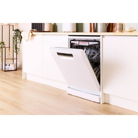 White freestanding dishwasher with open door revealing loaded rack, set in a bright modern kitchen with light wood flooring