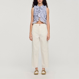 Model wearing Sandro Womens French Dress in clear, wide-leg silhouette, styled with a ruffled crop top and gold flat shoes.