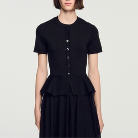 Model wearing Sandro Peplum Flared Knitted Dress in black, featuring short sleeves, button fastening, and peplum waist detail.