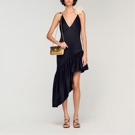 Model carrying Sandro yellow gold minibag with chain strap, styled with black asymmetric ruffle dress and strappy heels