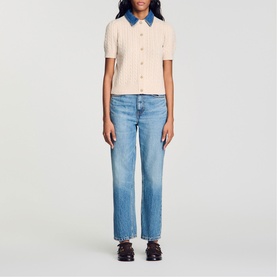 Model wearing Sandro cream cable-knit short-sleeve polo top with denim collar, styled with light-wash straight-leg jeans