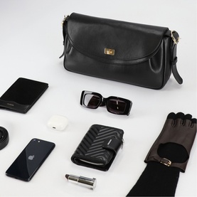 Sandro Le Mambo Leather Shoulder Bag in black with gold swivel clasp, styled with sunglasses, gloves, phone and wallet in a flatlay.