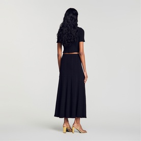 Model wearing Sandro Womens French Dress in black, shown from behind, styled with gold strappy heeled sandals