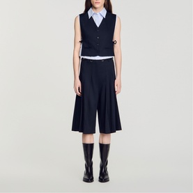 Model wearing navy sleeveless waistcoat and wide-leg culottes, styled with a light blue shirt and black knee-high boots.