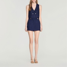 Model wearing Sandro Womens French Dress in dark navy tweed, sleeveless double-breasted style with gold buttons, styled with tan heeled sandals.