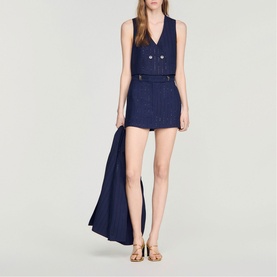 Model wearing Sandro Womens French Dress in dark navy, sleeveless V-neck style with gold buttons, styled with gold flat sandals.