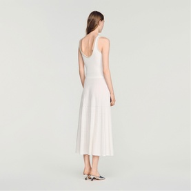 Model wearing Sandro Womens French Dress in clear white, midi length with flared skirt, shown from back, styled with two-tone heels