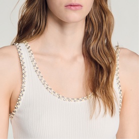 Model wearing Sandro ribbed white tank top with crystal and pearl embellished neckline and straps, close-up detail shot