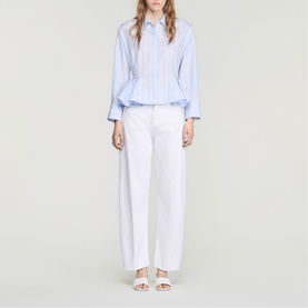 Model wearing Sandro sky blue striped peplum shirt with white wide-leg trousers and white sandals