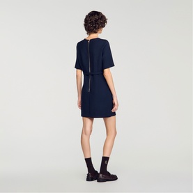 Model wearing Sandro Womens French Dress in navy blue, short sleeves, zip-back detail, styled with black loafers and socks.