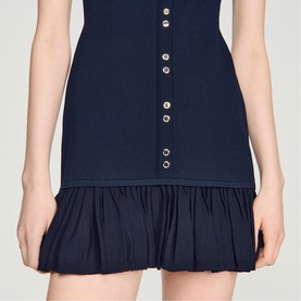 Model wearing Sandro Ruffle Mini Knitted Dress in midnight blue, showing decorative button placket and ruffled hem detail.