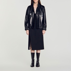 Model wearing Sandro black patent leather oversized jacket and black midi skirt, styled with knee-high boots