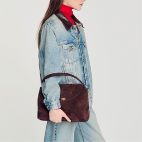 Model carrying Sandro brown suede shoulder bag with gold hardware, styled with denim jacket and wide-leg jeans