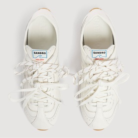 Sandro women's white leather trainers, overhead shot showing wide flat laces, brogue detailing and tan rubber sole