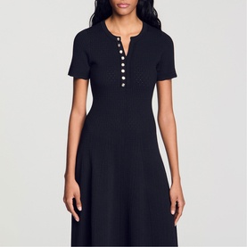 Model wearing Sandro Womens French Dress in black, featuring short sleeves, V-neckline with pearl button placket, and A-line skirt silhouette.