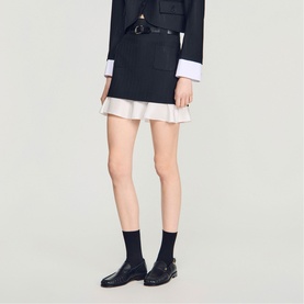 Model wearing Sandro Womens French Dress in black, styled with white frill hem underlayer, black socks and black buckle loafers